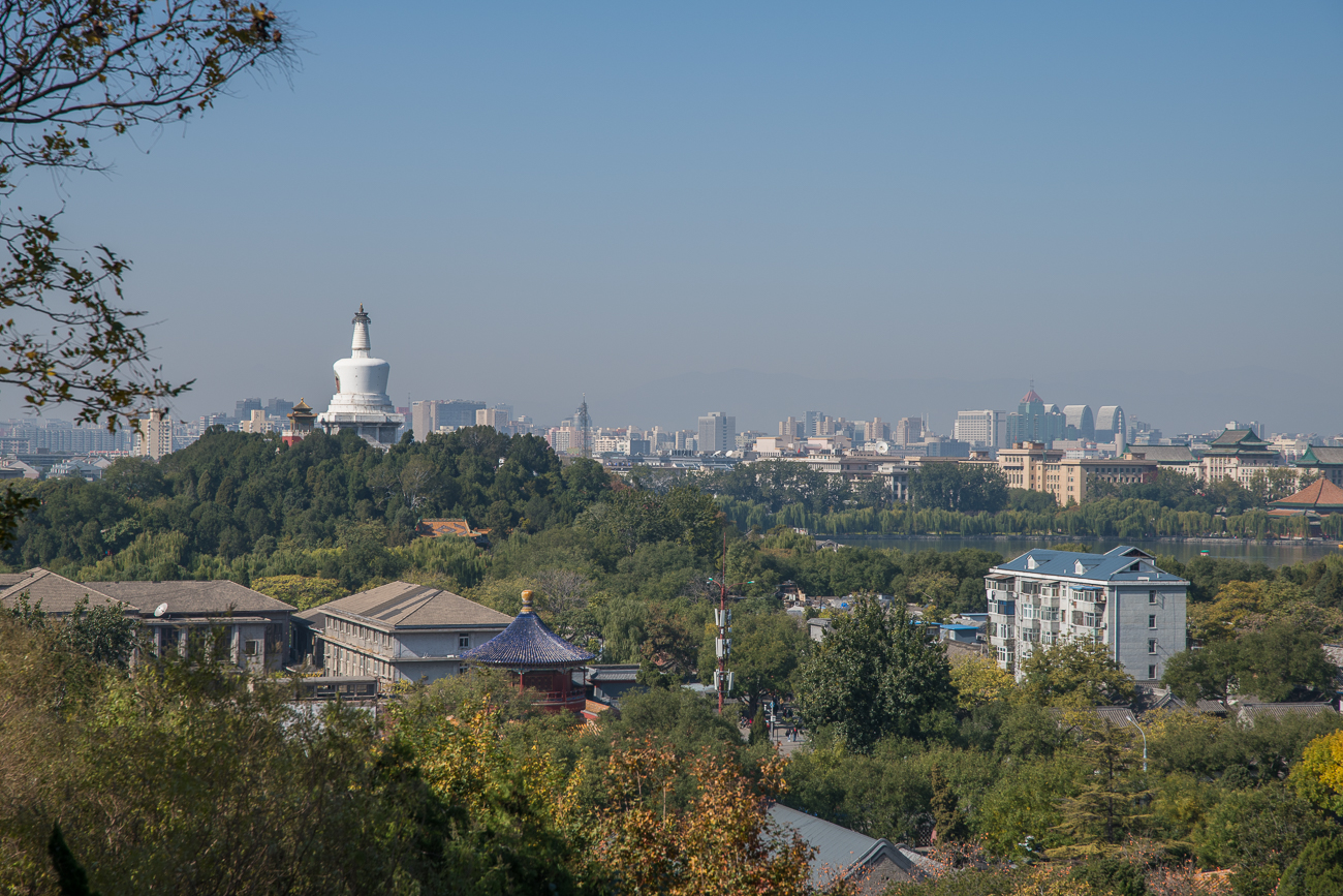 Blick vom Aussichtshügel auf die Pagode im Beihai Park und die Hochhäuser im Hintergrund