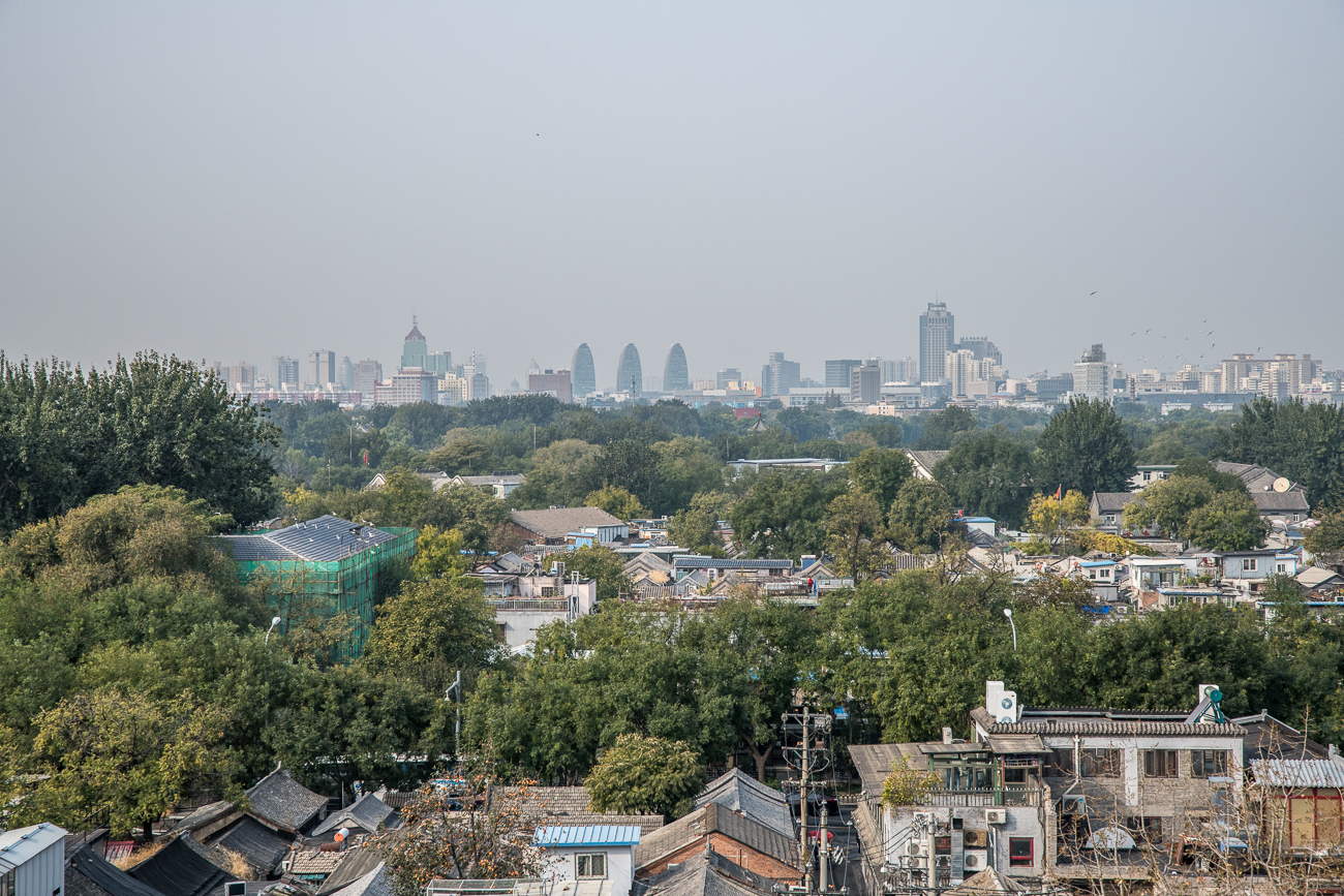 Hutong und im Hintergrund die moderne Stadt